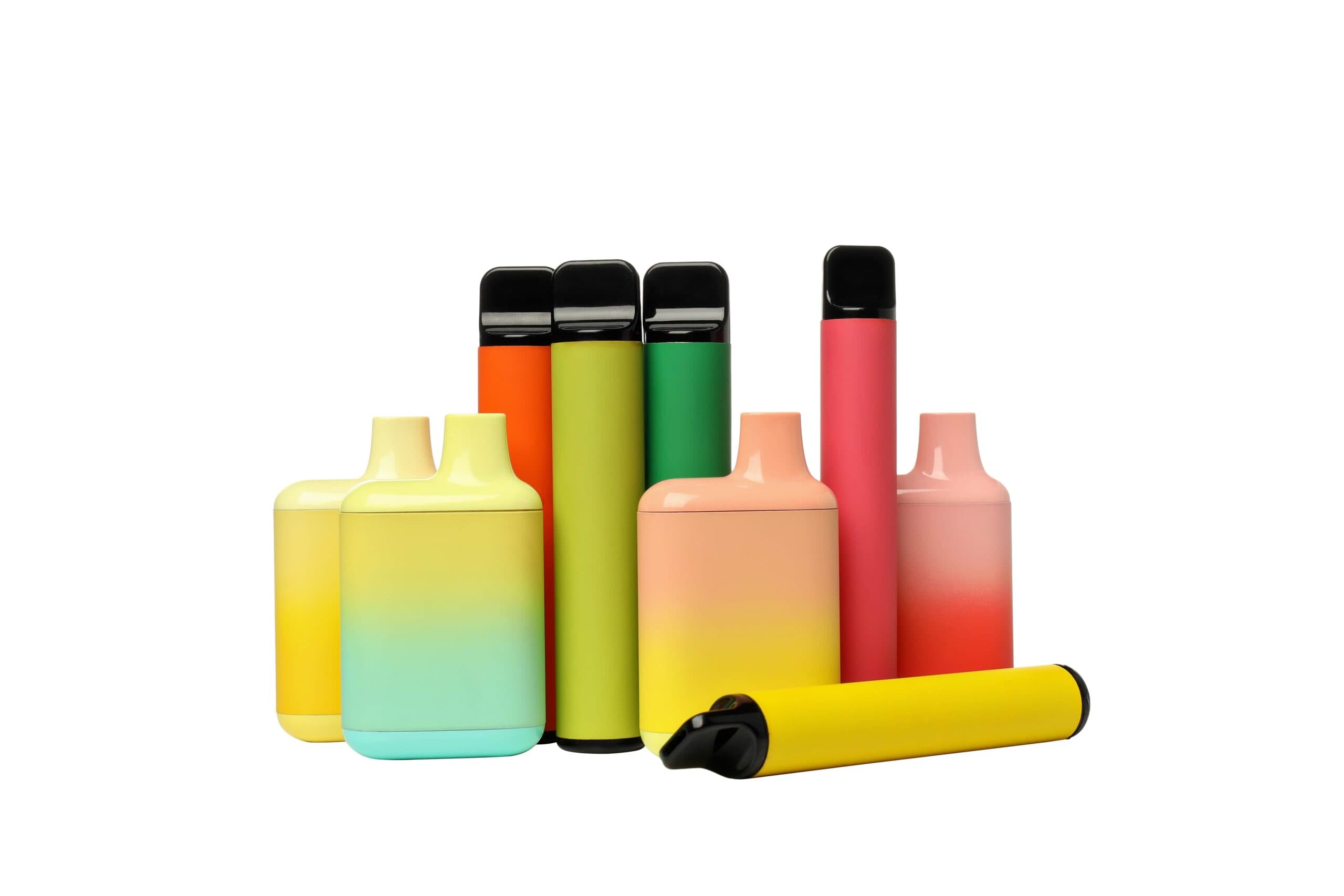 Colorful assortment of disposable vape devices in various shapes and designs on white background