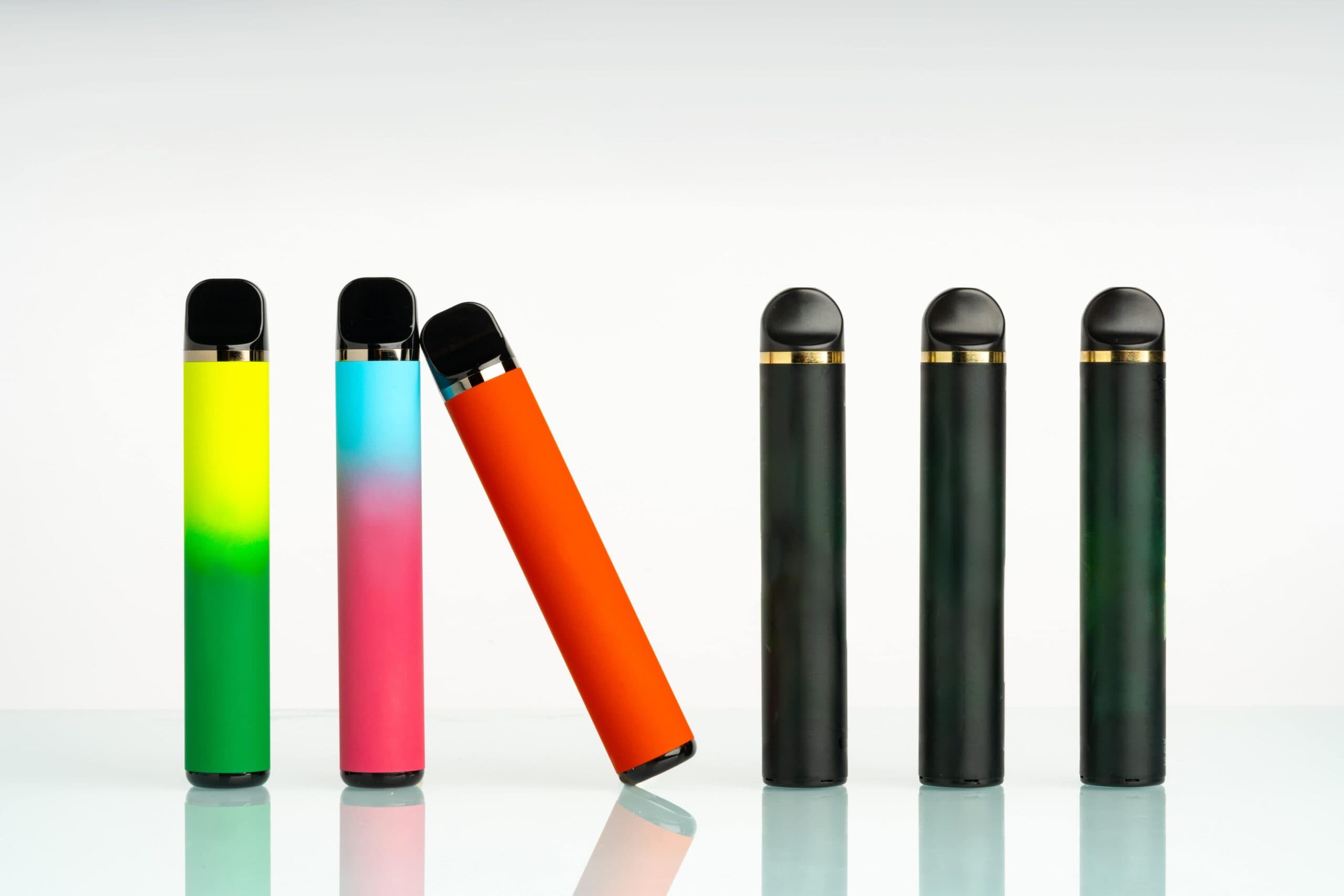 Disposable and refillable vape pens shown side by side with colorful and matte finishes