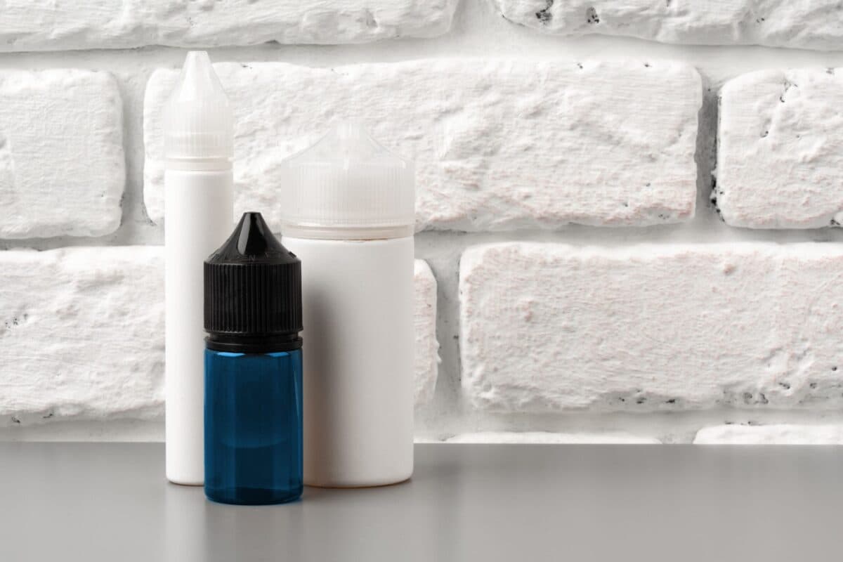 Vape juice bottles including a blue container for different nicotine strengths and flavors