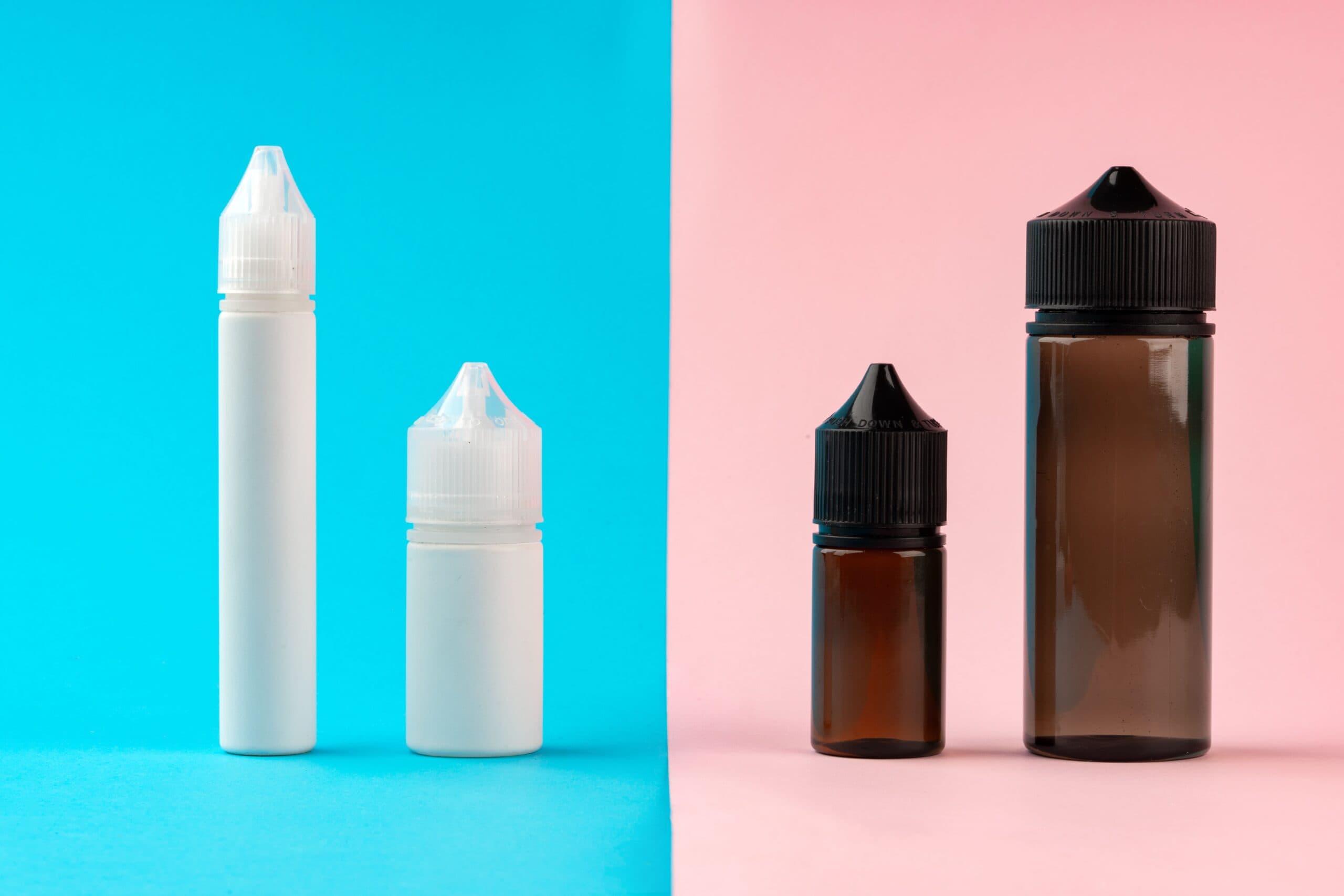Comparison of vape juice bottles on split blue and pink background, showing white plastic and amber glass e-liquid containers
