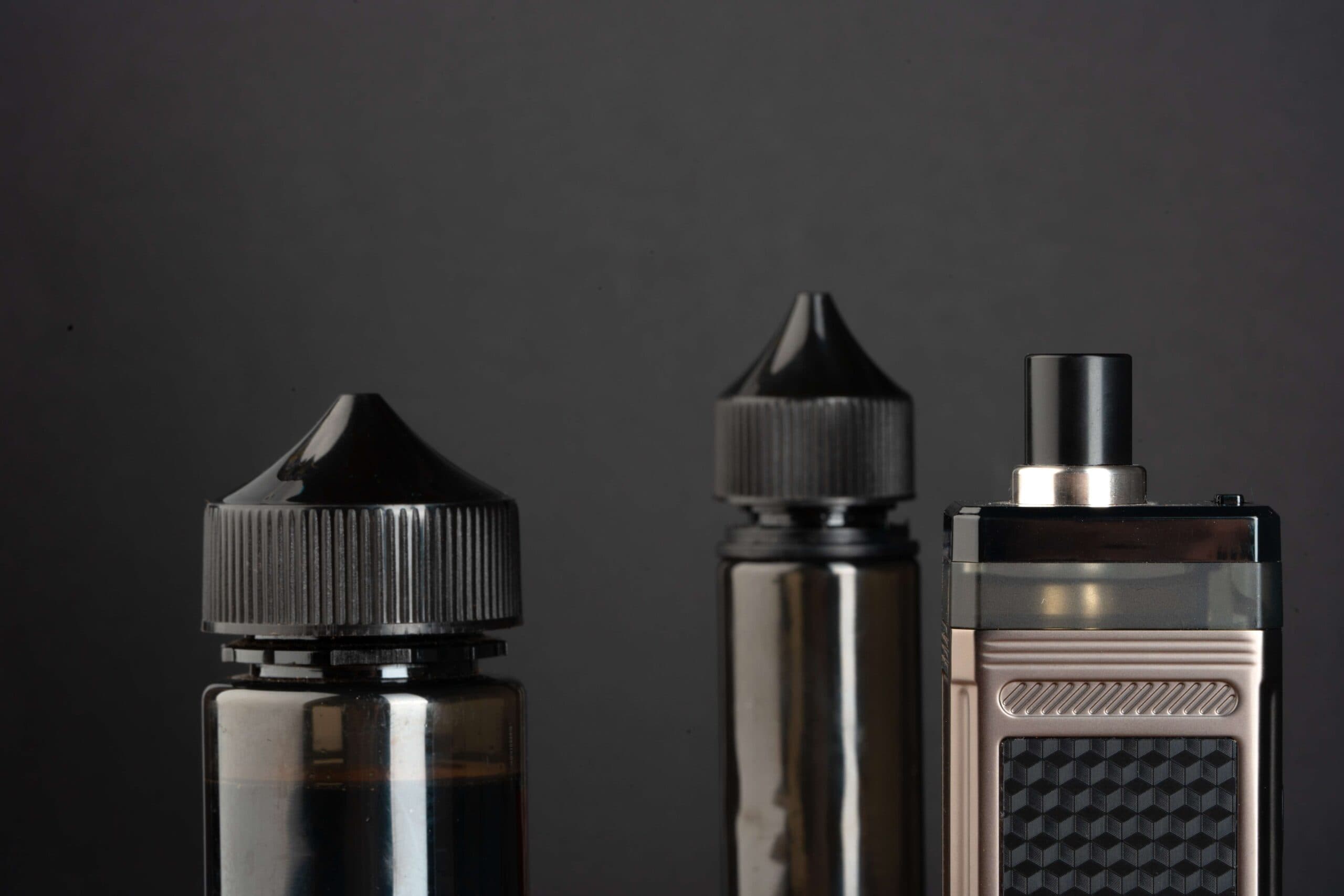 Vape juice bottles and vape device stored in a dark, cool environment to maintain freshness and prevent degradation.